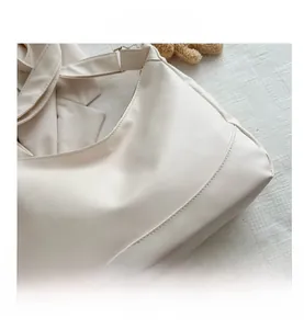Detailed close-up of cream PU leather hobo bag with zip closure and stitching