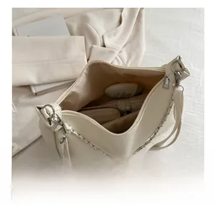 Detail view of spacious interior storage for off-white faux leather shoulder bag