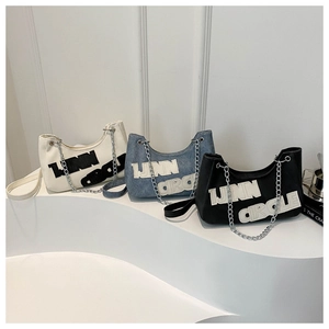 Three trendy half-moon handbags in white, denim blue, and black with chain straps