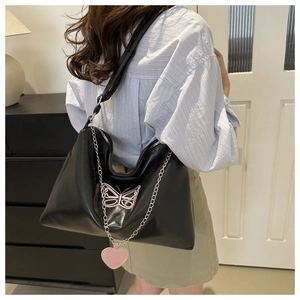 Detail of black Hobo bag with pink butterfly embroidery and metal decorative chain