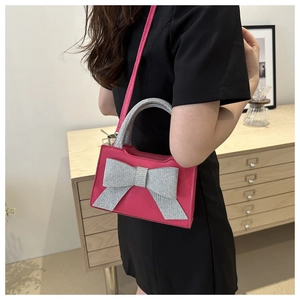 Détail d'un sac à main rose en PU avec un grand nœud en paillettes argentées