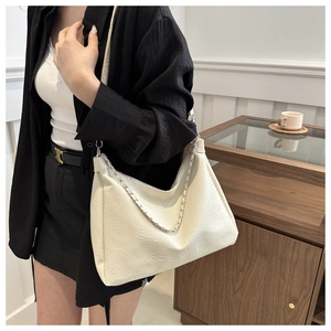 Detail of white PU leather shoulder bag with silver chain and adjustable strap