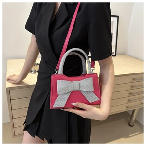 Détail d'un sac à main rose avec un grand nœud en strass argenté et poignée chic