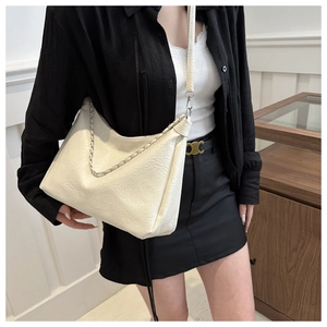 Close-up of the crinkled creamy white leather shoulder bag with silver chain detail