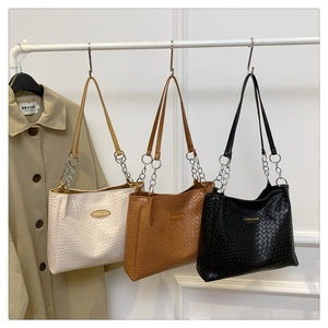 Three textured woven tote bags in white, tan and black with gold metal chain straps