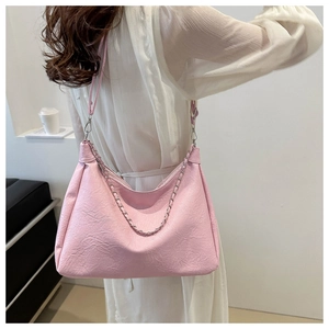 Close-up of pink pleated hobo bag with silver chain strap and soft PU leather texture