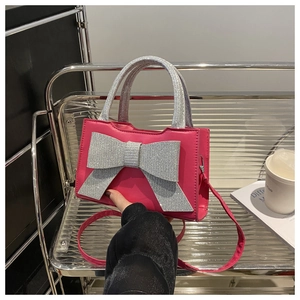Détail du sac à main rose en cuir PU avec nœud à paillettes argentées sur étagère