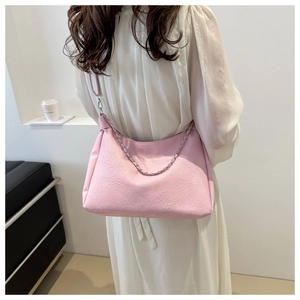 Detailed back view of model wearing a pink large capacity faux leather shoulder bag with chain