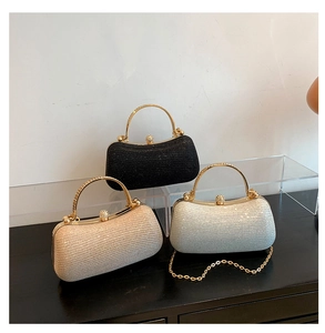 Dettaglio di tre pochette da sera glitterate con manici dorati e chiusure a diamante