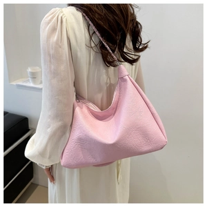 Detail of pink crescent bag with pleated texture and stylish metal chain strap