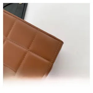 Detail of brown quilted faux leather handbag showing precise stitching and textured grid pattern