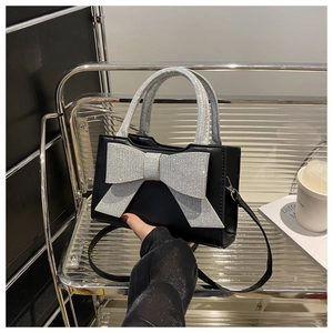 Vue détaillée du sac à main carré noir avec une décoration de nœud en strass argentés