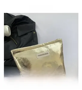 Close-up of golden metallic textured bag with Fashion Bag label and top zipper detail