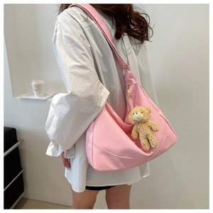 Pink crescent hobo bag with adjustable strap and cute brown plush bear charm detail