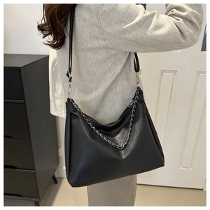 Detail of black lychee grain crossbody bag with chunky silver chain and adjustable strap