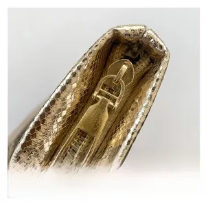 Detail of the golden snake skin textured fabric with high-quality polished metal zipper