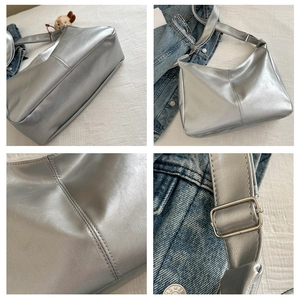 Detail view of silver metallic shoulder bag showing stitching and adjustable strap buckle