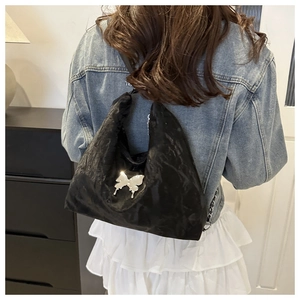 Detail showing side view of black hobo bag with silver butterfly clasp on model