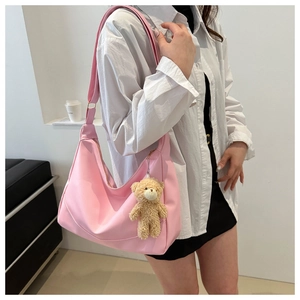 Pink nylon shoulder bag with adjustable strap and cute brown plush bear charm detail
