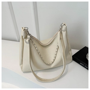 Detailed macro view of the cream white faux leather texture and silver chain strap