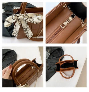 Close-up of brown quilted handbag featuring metal chain strap and decorative silk scarf