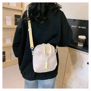 Détail du sac bandoulière beige imperméable avec tirettes de fermeture éclair jaunes