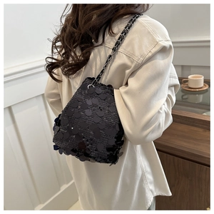 Fashionable black sequin bucket bag worn by model with elegant chain shoulder strap