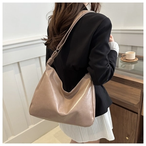 Detail view of large minimalist light brown tote bag on model for casual commuting