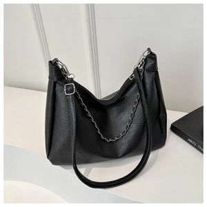 Detailed shot of black lychee grain leather handbag with silver chain and shoulder strap