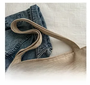 Detail of beige corduroy tote bag with reinforced handles and vertical ribbed texture