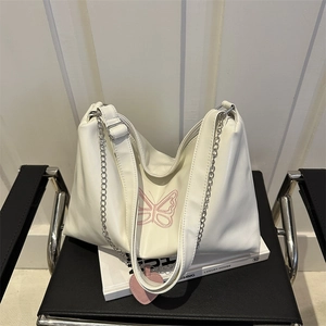 White faux leather shoulder bag with pink butterfly embroidery and heart charm detail