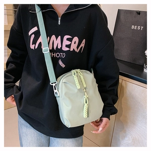 Sac bandoulière en nylon vert pâle avec double fermeture éclair et cordons tressés