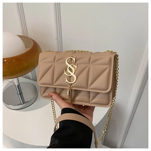 Dettaglio borsa trapuntata beige con logo S dorato, nappine e tracolla a catena elegante