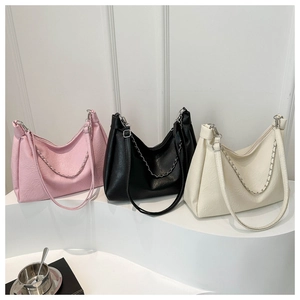 Detailed display of pink, black, and cream hobo bags with metallic chain accents