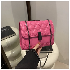 Détail du sac à chaîne rose matelassé avec fermoir noir et motif à losanges élégant