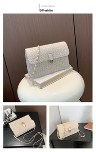 Close-up of cream woven square bag featuring a light gold metal chain and oval twist lock