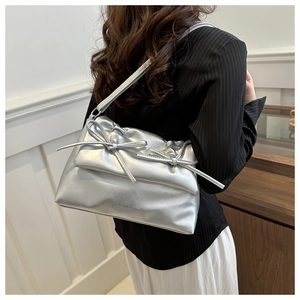 Silver metallic shoulder bag featuring bow details and Fashion & Bags text on model
