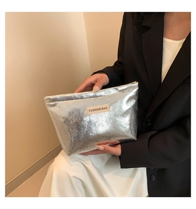Handheld silver sequin cosmetic bag featuring a rectangular zipper and fashion label