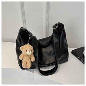 Detail of black PU shoulder bag with a cute khaki plush bear keychain pendant