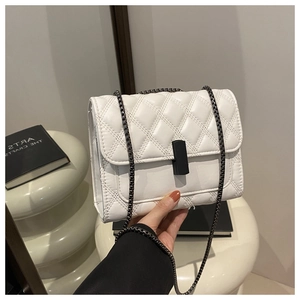 Vue détaillée du sac matelassé blanc avec chaîne et fermoir tournant noir minimaliste