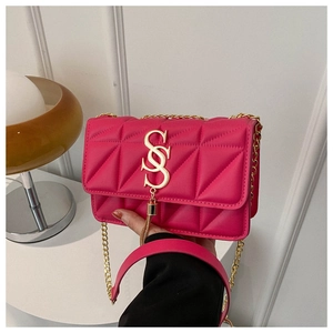 Dettaglio macro della borsa trapuntata rosa con logo SS dorato e tracolla a catena