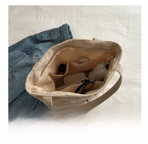 Internal view of beige canvas tote bag with compartments showing large storage capacity