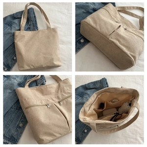 Detail view of beige corduroy tote bag showing metal zippers and spacious interior compartments