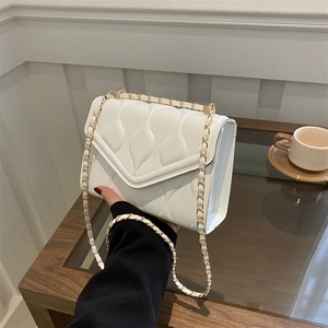 White quilted chain shoulder bag with envelope flap and wavy stitching pattern