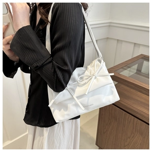 Model wearing white PU shoulder bag with pleats and decorative bow for chic commuter style