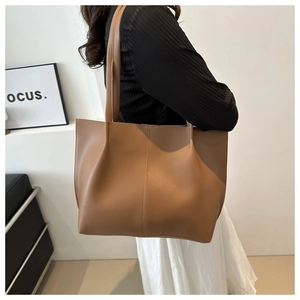 Brown leather tote bag featuring vertical stitching and large capacity for commuting