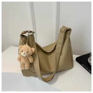 Detail of khaki PU leather hobo bag with wide shoulder strap and cute bear charm