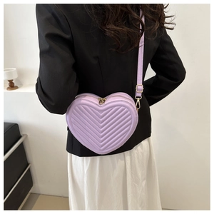 Detail view of the purple heart-shaped crossbody bag with elegant V-shaped quilting texture