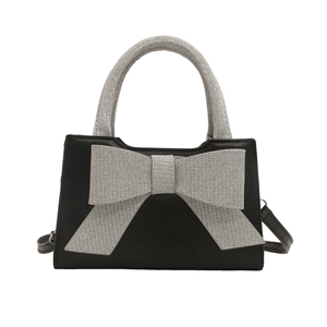 Sac à main chic en cuir noir avec un grand nœud pailleté argenté et une poignée