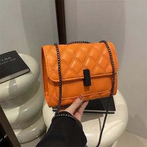 Sac bandoulière matelassé orange avec fermoir noir et motif à losanges chic